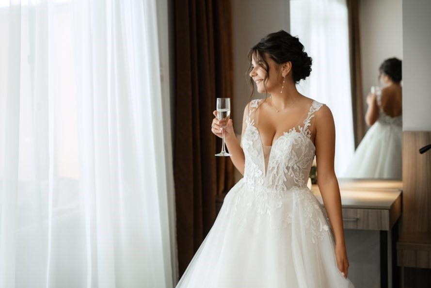 Mlada nosi venčanicu dok drži čašu šampanjca