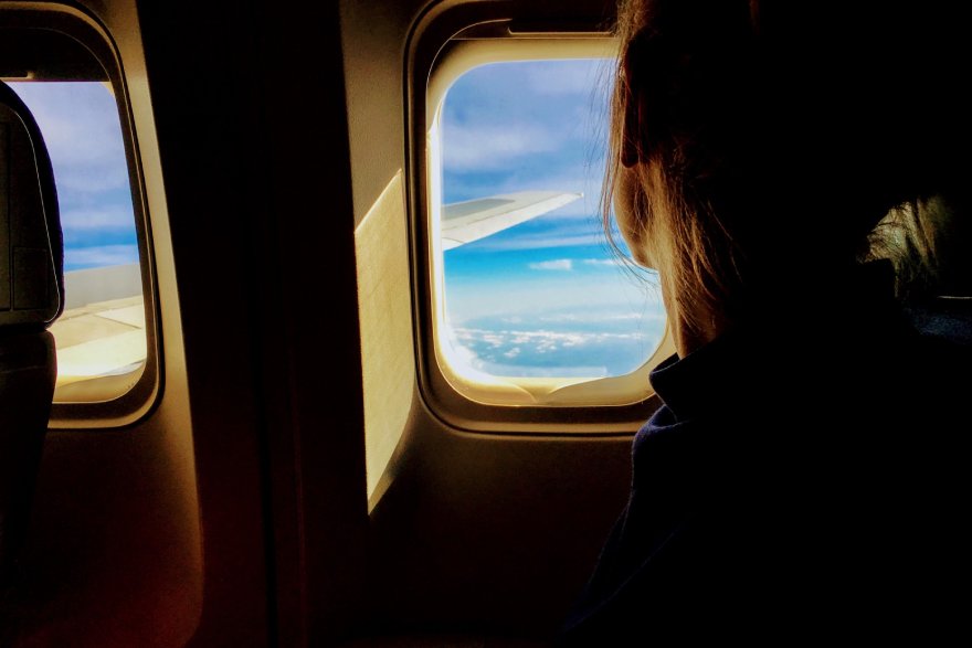 Žena gleda kroz prozor u avionu
